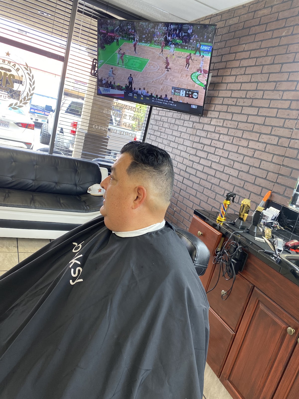 Client with fresh fade watching NBA playoffs in shop